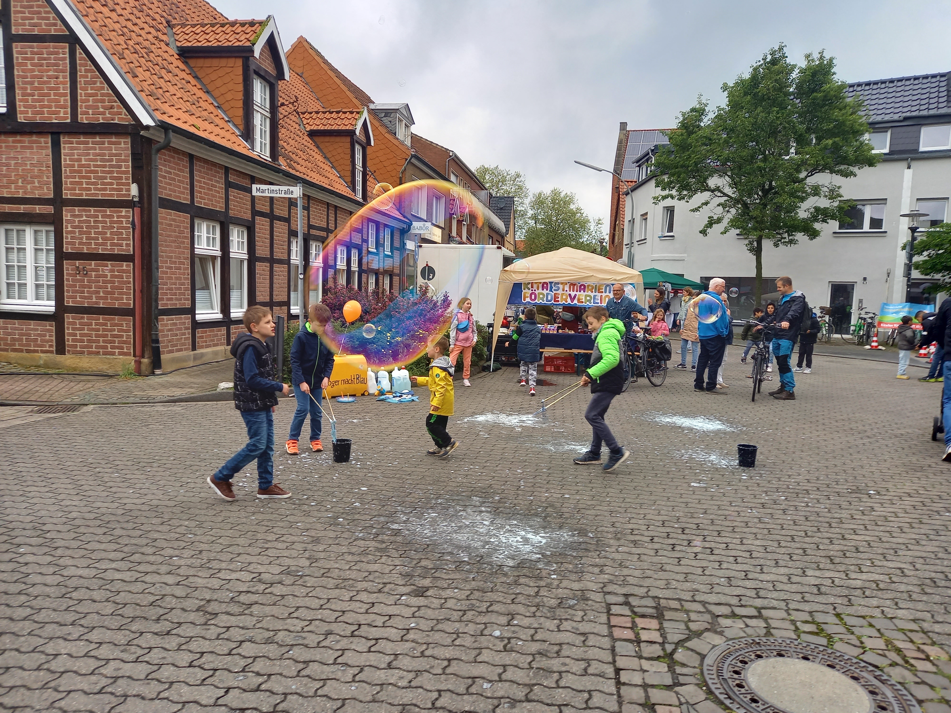 Kinder spielen beim Stadtfest in der Altstadt mit einer bunten Riesenseifenblase